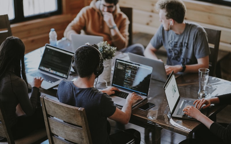 IT team collaborating around laptops